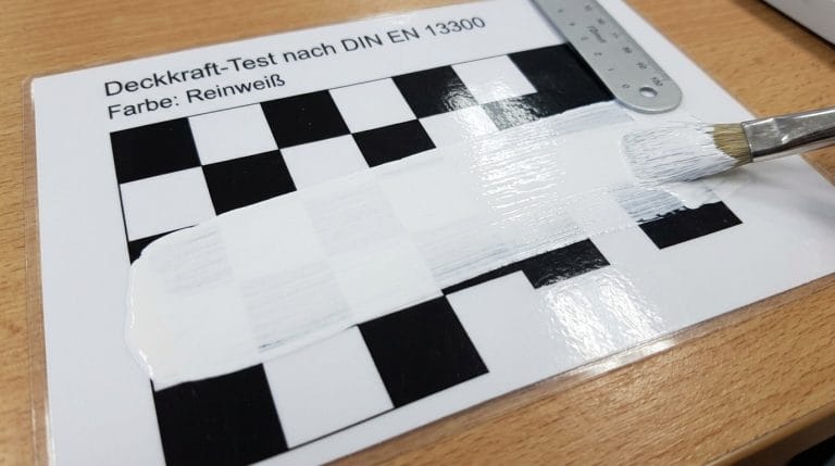 Deckkraft-Test nach DIN EN 13300 mit Reinweiß-Farbe auf Schwarz-Weiß-Schachbrettmuster, teilweise überstrichen