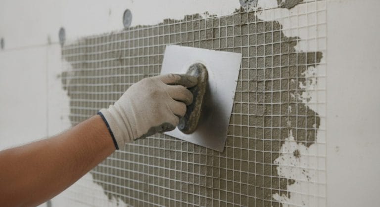 Einbettung von Armierungsgewebe in Armierungsmörtel auf einer WDVS-Fassade